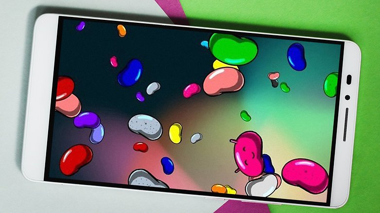 Um smartphone mostrando feijões de gelatina coloridos na tela contra um fundo verde e rosa. Um smartphone mostrando feijões de gelatina coloridos na tela contra um fundo verde e rosa.
