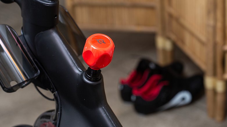 Mit diesem Drehknauf stellt Ihr den Widerstand ein. Durch einen Druck auf den Knauf selbst stoppt Ihr die Schwungscheibe. Diese bei hohem Tempo per Beinkraft stoppen zu wollen, ist keine gute Idee. Peloton Bike+ Produktfoto