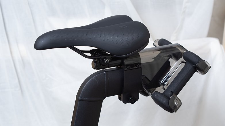 Einige Kurse kombinieren auch Radfahren mit leichtem Hanteltraining – dafür gibt es diese Aufnahme am Sattel. Zwar hat Peloton auch schwerere Hanteln im Programm, doch diese passen nicht in die Plastik-Aufnahme hinein. Peloton Bike+ Produktfoto