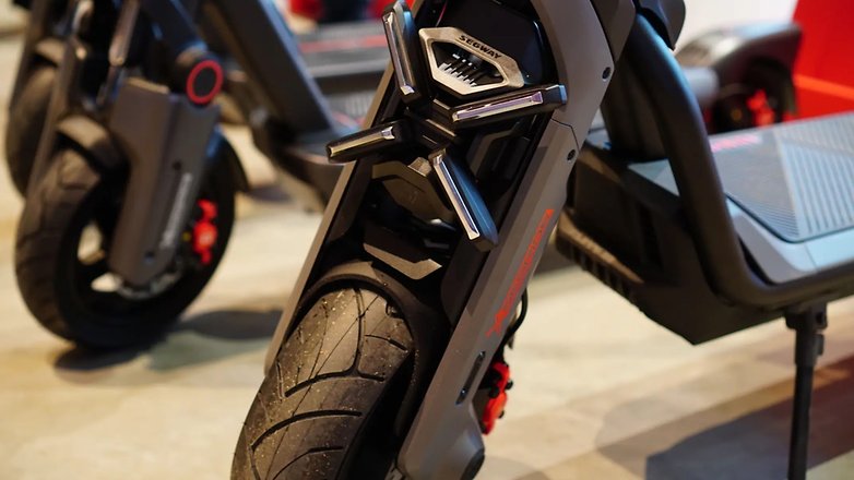 Nahaufnahme eines Segway Ninebot Elektrorollers mit Vorderreifen und Rahmendetails. Nahaufnahme eines Segway Ninebot Elektrorollers mit Vorderreifen und Rahmendetails.