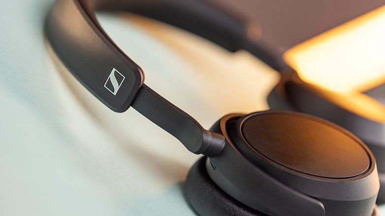 Le casque sans fil Sennheiser Accentum Plus Wireless vu de côté et posé à plat avec un zoom sur les charnières de son arceau