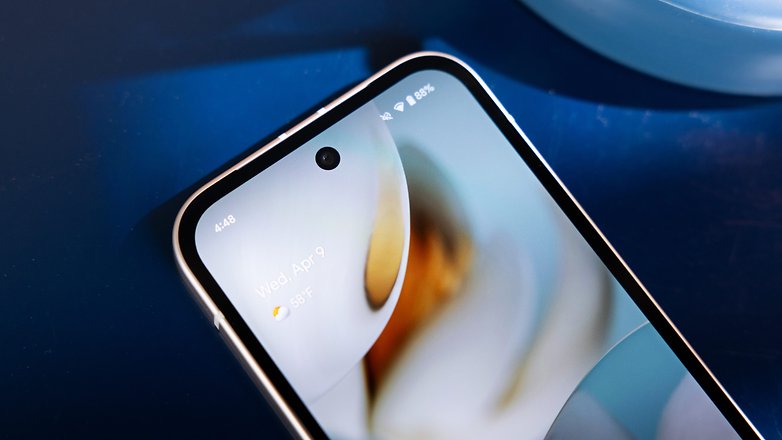Close-up de um smartphone Google Pixel 9a mostrando a tela inicial com a data e o clima. Close-up de um smartphone Google Pixel 9a mostrando a tela inicial com a data e o clima.