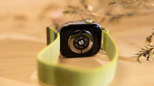 Rückansicht einer Huawei Watch Fit 4 Pro mit grünem Armband auf einer Holzoberfläche.