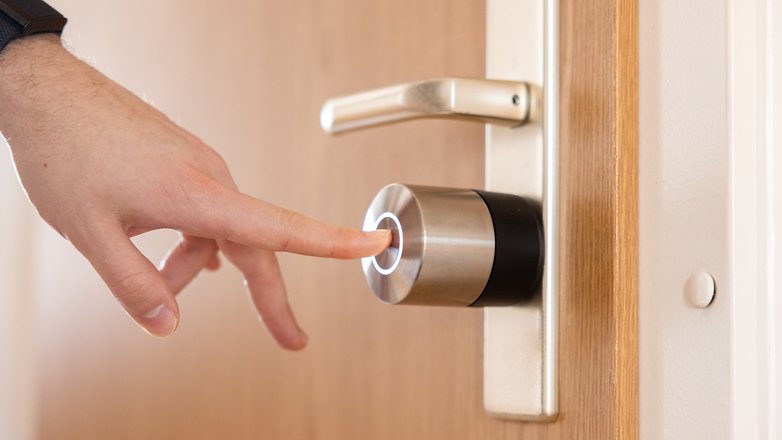 Eine Hand steht kurz davor, ein Nuki Smart Lock Pro an einer Tür zu berühren. Eine Hand steht kurz davor, ein Nuki Smart Lock Pro an einer Tür zu berühren.