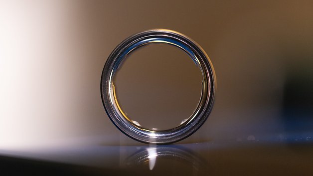 Close-up de um Oura Ring, mostrando seu design elegante e superfície brilhante.