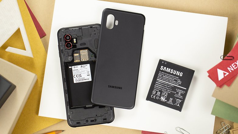Le Galaxy XCover 6 Pro vu de haut avec le couvercle retiré pour laisser apparaître la batterie amovible Le Galaxy XCover 6 Pro vu de haut avec le couvercle retiré pour laisser apparaître la batterie amovible