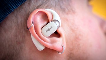 A close-up of Shokz OpenFit 2 wireless earphones resting in an ear.