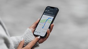 A person holding a smartphone displaying Apple Maps with a blue route towards Bernauer Straße.