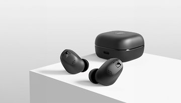 Schwarze Sennheiser Accentum True Wireless-Ohrhörer neben ihrem Ladecase auf einer weißen Oberfläche.