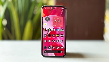 A Google Pixel 9 Pro XL smartphone displaying a colorful home screen with various app icons and a clock.