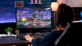A person playing a fighting game on a computer with a keyboard, displaying action on the screen.