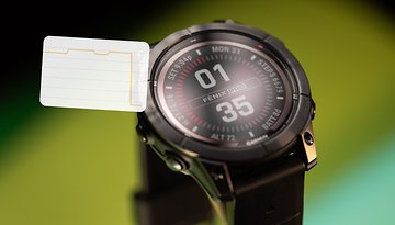 Nahaufnahme einer Garmin Fenix 7 Pro Solar Smartwatch, die Uhrzeit und Fitnessdaten anzeigt.